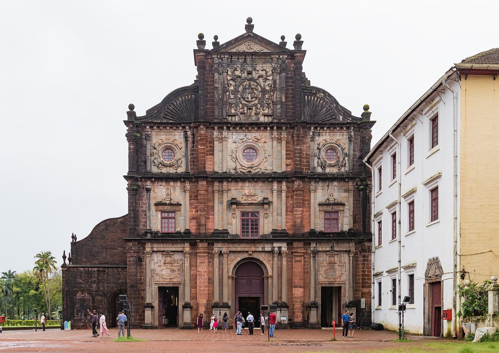 The laterite front of the Basilica of Bom Jesus in Old Goa, visitors on the square